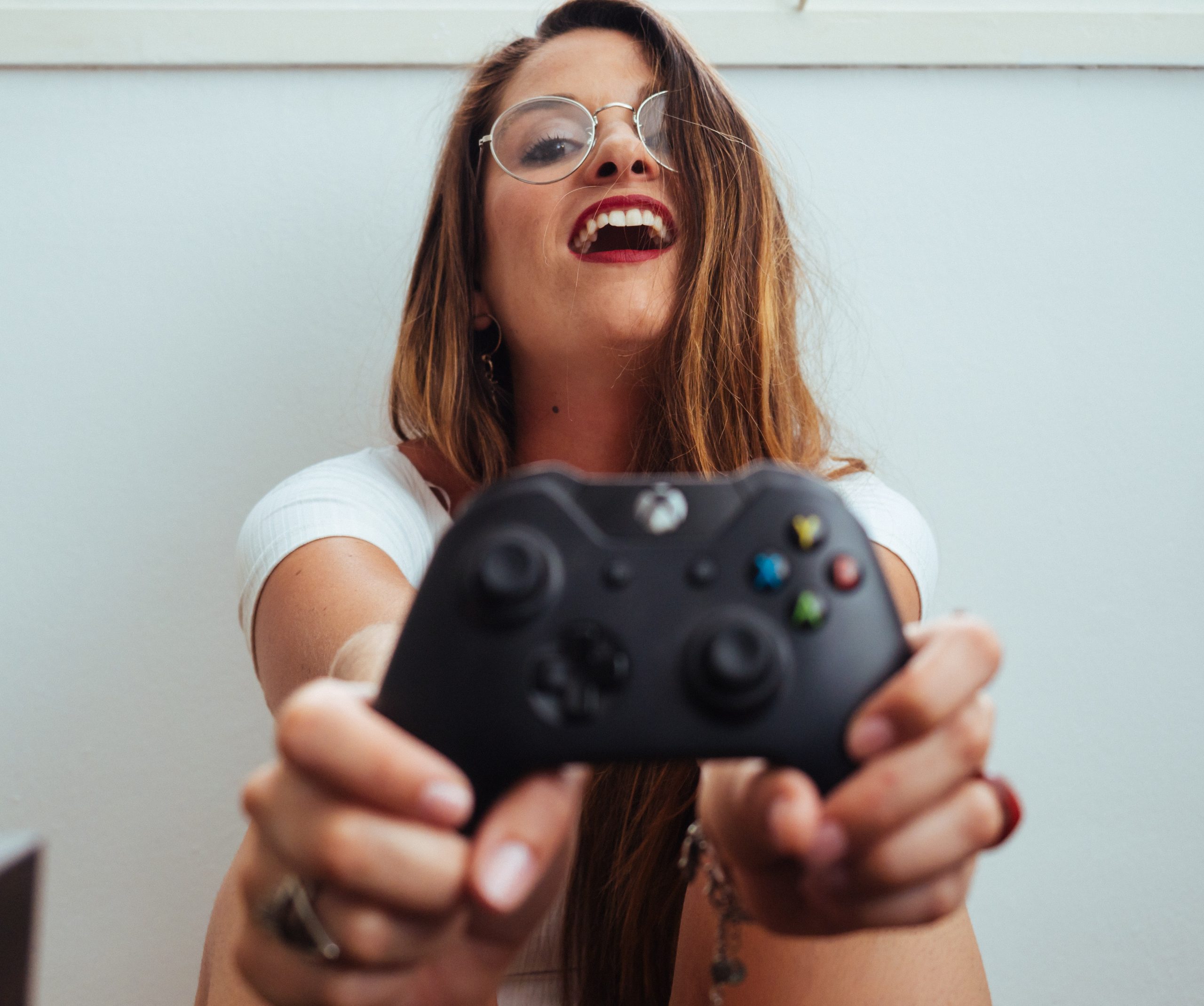 Girl holding an Xbox One controller and laughing