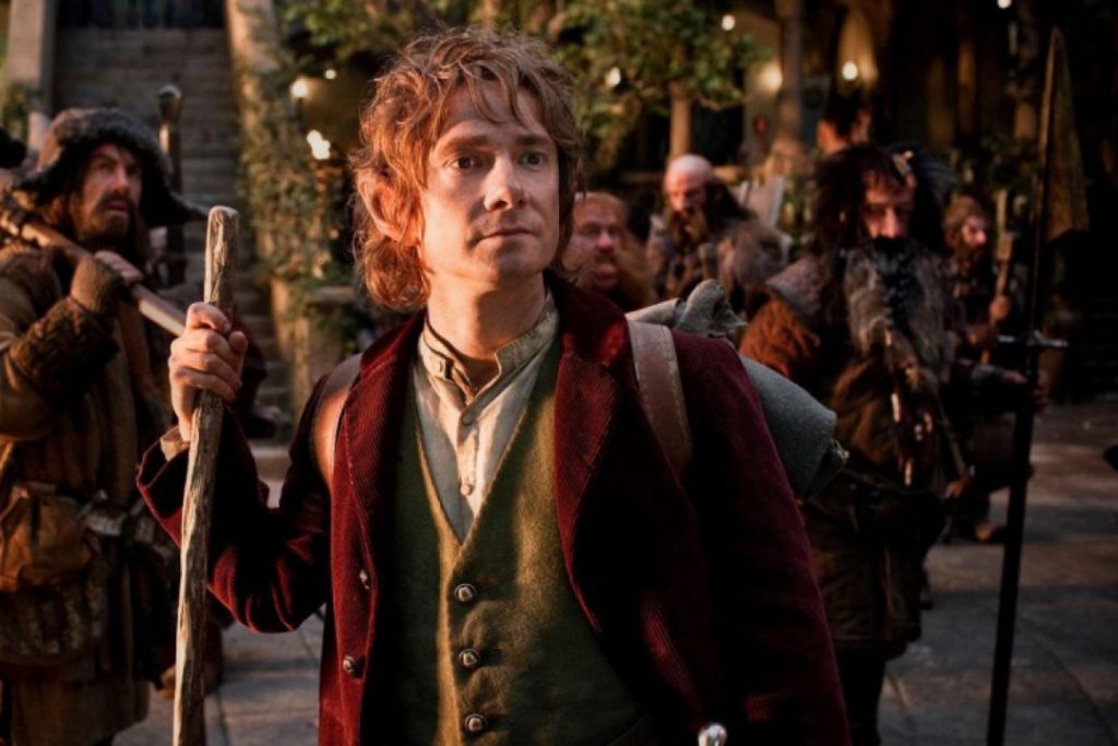 The adventurer Bilbo Bggins, a Hobbit, stands in front of a group of dwarves